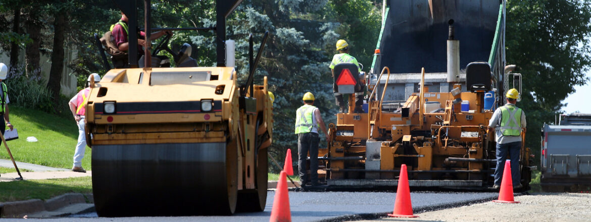 An asphalt spreader is used to place the first layer of asphalt on a city street renewal project.